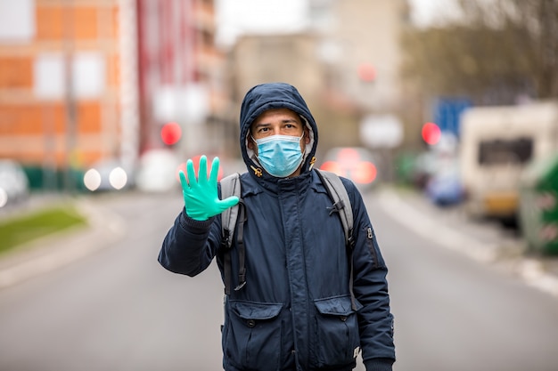 Foto portret van volwassen man, nee zeggen tegen coronavirus infectie met het dragen van medische chirurgische blauwe gezichtsmasker