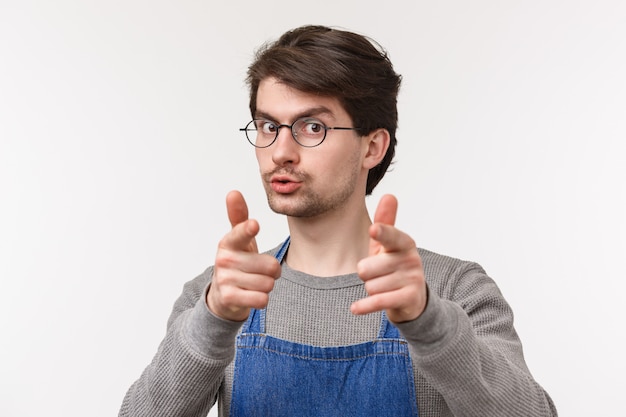 Portret van vriendelijke vrolijke jonge mannelijke werknemer in schort