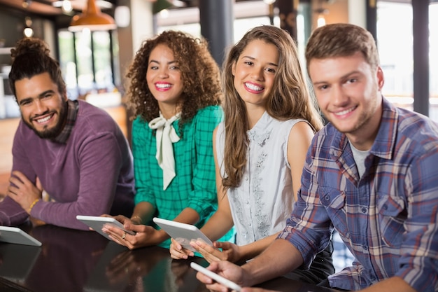 Portret van vrienden die digitale tabletten in restaurant houden