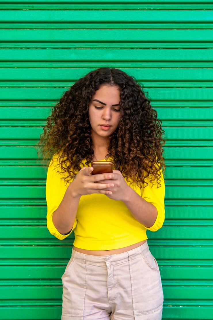 Portret van vrij Braziliaans meisje met smartphone Elegante Latijns-Amerikaanse vrouw uit Brazilië met krullend haar