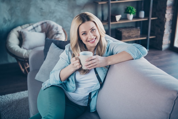 Portret van vrij leuke golvende haired vrouw die aromatische koffie drinkt