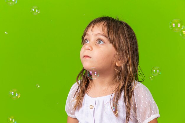 Portret van vrolijk blank meisje geïsoleerd op groene achtergrond