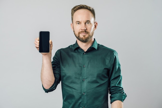 Portret van vrolijke aantrekkelijke man met smartphone