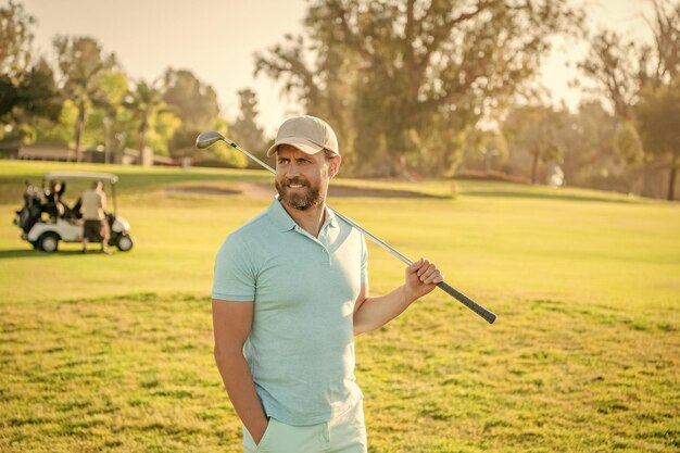 Portret van vrolijke golfer in pet met golfclubsporter