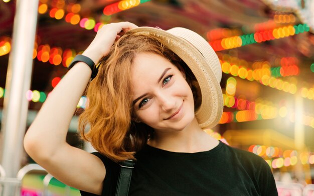 Portret van vrolijke hipster vrouw met hoed in pretpark