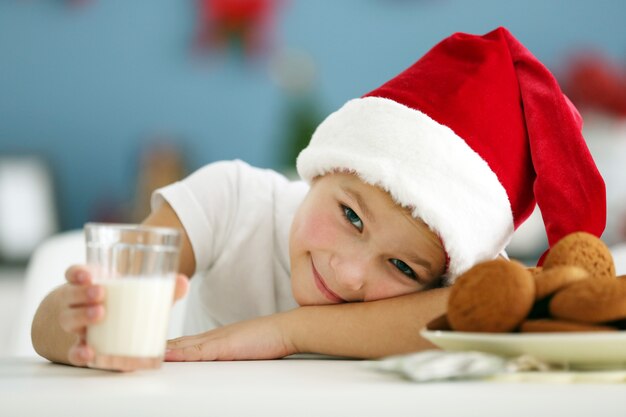 Portret van vrolijke jongen in ingerichte kerstkamer, close-up