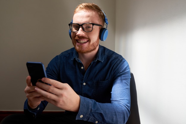 Portret van vrolijke man met smartphone