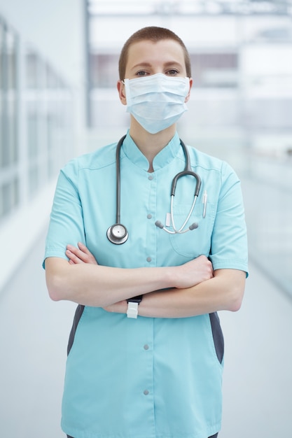 Portret van vrouw arts die medisch masker draagt.