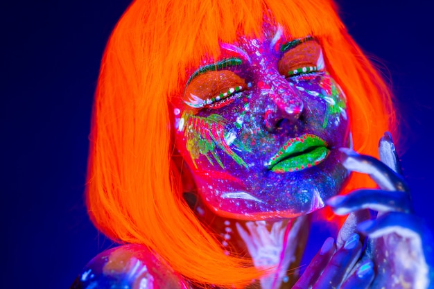 Portret van vrouw binnen met neonmake-up. Fluorescerende verf in ultraviolet licht