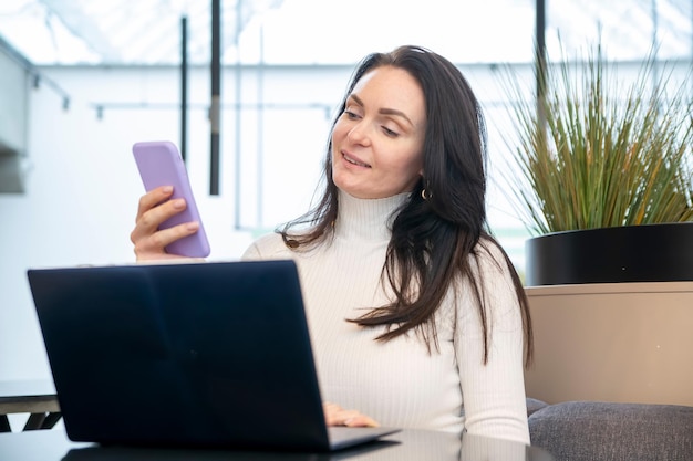 portret van vrouw die aan laptop en smartphone werkt