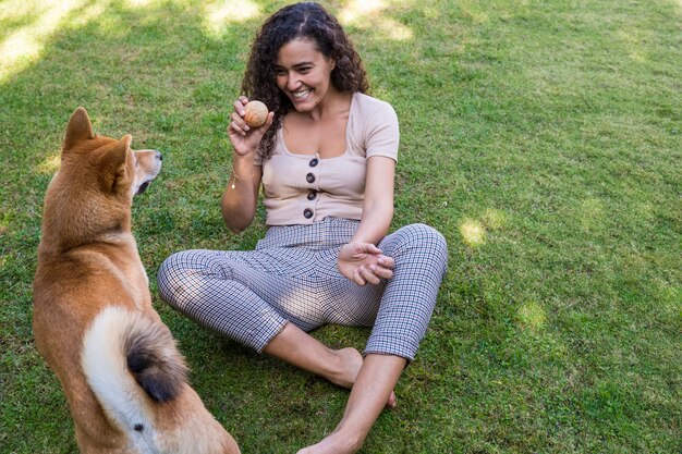 Portret van vrouw die en haar hond in de tuin koestert kust