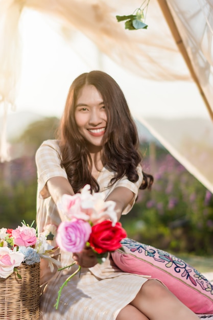 Portret van vrouw het stellen in een tent op een bloemgebied