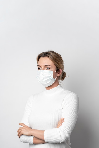 Foto portret van vrouw met het chirurgische masker stellen