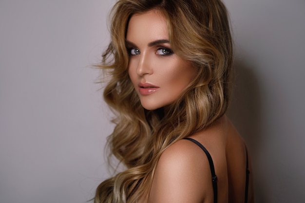 Portret van vrouw met mooi krullend haar en professionele make-up