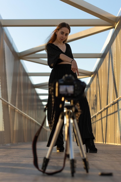 Portret van vrouw modellering voor een camera gemonteerd op een statief Vrouw op een brug poseren voor een camera