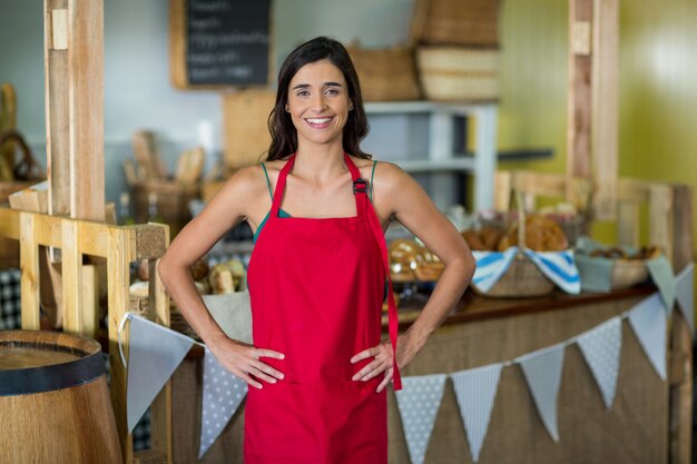 Portret van vrouwelijk personeel permanent met handen op heup aan balie