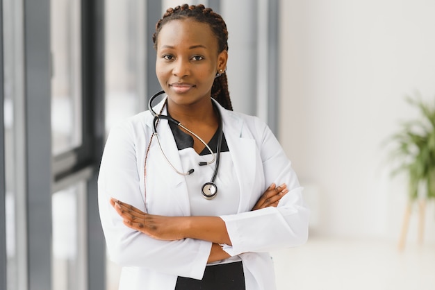 Portret van vrouwelijke Afrikaanse Amerikaanse arts die zich in haar bureau bij kliniek bevindt