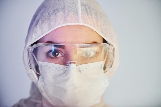 Portret van vrouwelijke arts wetenschapper in laboratoriumjas defensieve brillen en masker