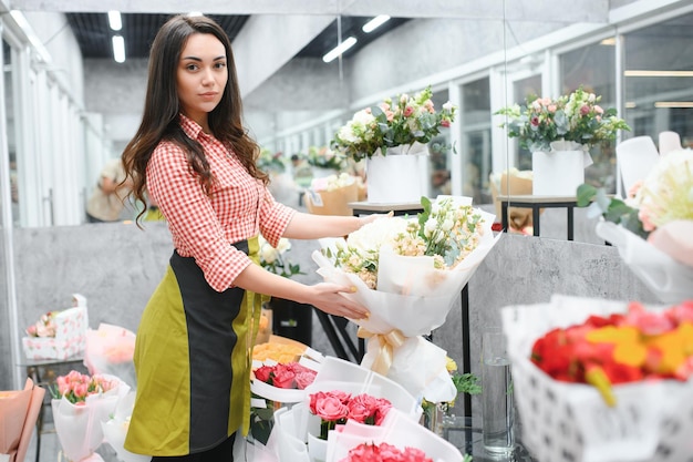 Portret van vrouwelijke bloemist in haar bloemenwinkel