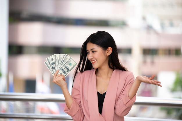 Portret van vrouwelijke ondernemers kijken naar geld bij de hand buiten.