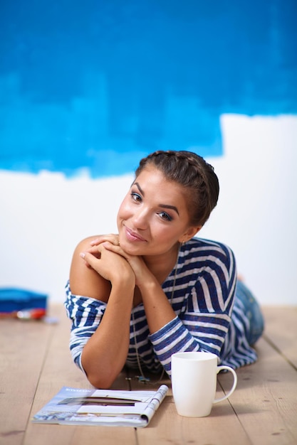Portret van vrouwelijke schilder zittend op de vloer na het schilderen