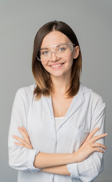 Foto portret van vrouwelijke wetenschapper die zich met haar gekruiste wapens bevindt