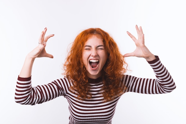 Foto portret van woede agressieve roodharige meisje, hand opgestaan en schreeuwen met gesloten ogen