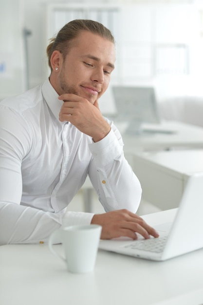 Portret van zakenman die aan tafel werkt met laptop