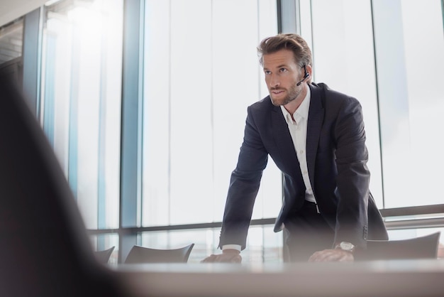 Portret van zakenman met bluetooth-headset die zich in vergaderruimte bevindt