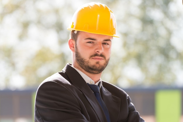 Portret van zakenman met gele helm op bouw