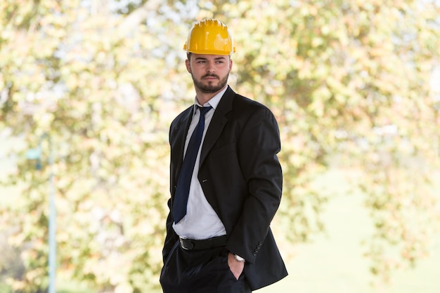 Portret van zakenman met gele helm op bouw