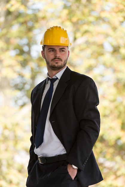 Portret van zakenman met gele helm op bouw