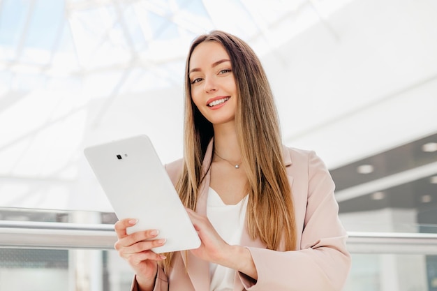 Portret van zakenvrouw met behulp van digitale tablet in het kantoorgebouw