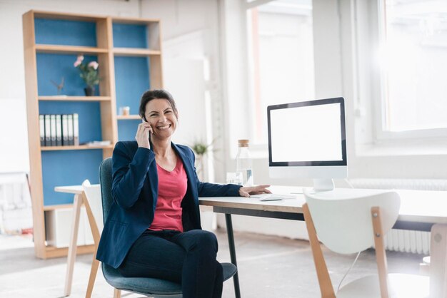 Portret van zakenvrouw zittend aan een bureau in een loft