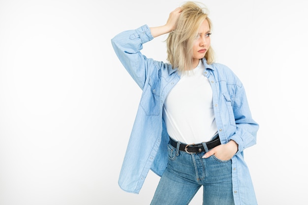 Portret van zeker meisje met blond kapsel in toevallige stijl op geïsoleerd wit