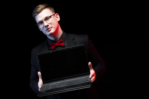 Portret van zekere knappe ambitieuze gelukkige elegante verantwoordelijke zakenman die laptop aanbieden aan een cliënt