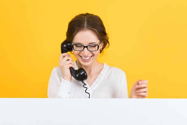 Portret van zekere mooie opgewekte glimlachende gelukkige jonge bedrijfsvrouw met telefoon