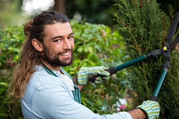 Portret van zekere tuinman met haagclippers bij tuin