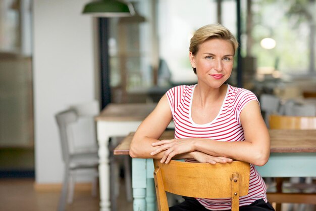 Portret van zelfverzekerde blonde vrouw zittend op een stoel