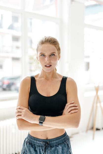 Portret van zelfverzekerde jonge vrouw in sportkleding