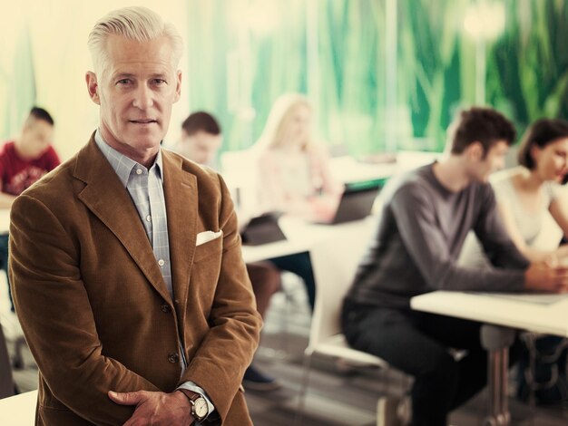 portret van zelfverzekerde leraar in schoolklas, studentengroep op klas op achtergrond