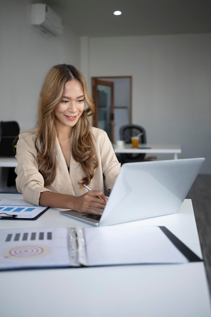 Portret van zelfverzekerde zakenvrouw die werkt met een laptopcomputer.