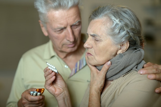 Portret van ziek senior koppel, vrouw met keelpijn?