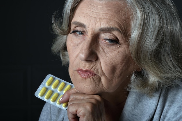 Portret van zieke senior vrouw met pillen