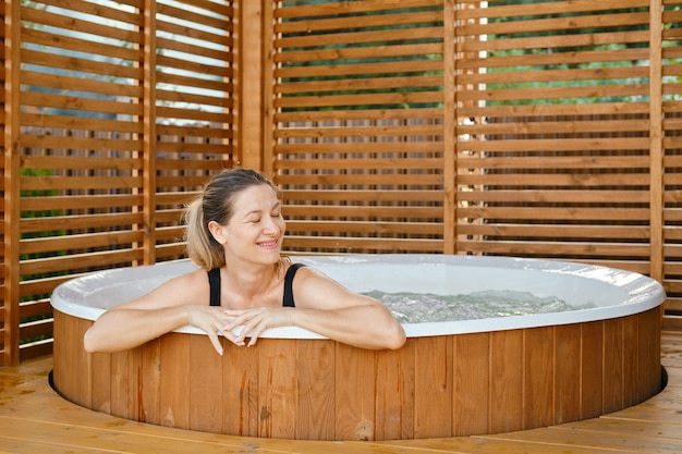 Portret van zorgeloze vrolijke glimlachende vrouw die tijdens haar vakantie ontspant in een bubbelbad