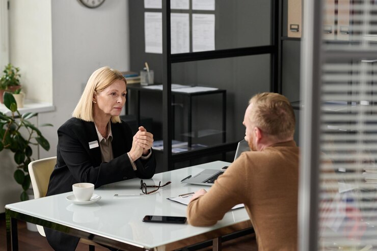 Foto portret van zorgzame maatschappelijk werker raadplegende man achter glazen wand in kantoor