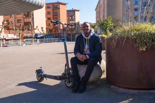 Portret van zwarte etnische mannelijke skateboarden op een elektrische skateboard nieuwe mobiliteit