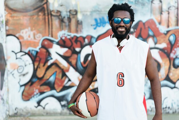 Portret van zwarte man met casual sportkleding en basketbal.