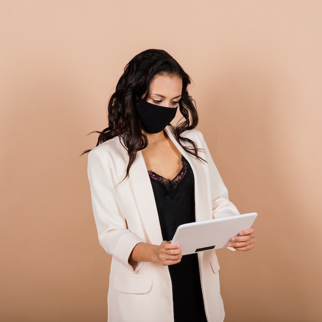 Portret van zwarte onderneemster die gezichtsmasker draagt tijdens virusepidemie in een studio.