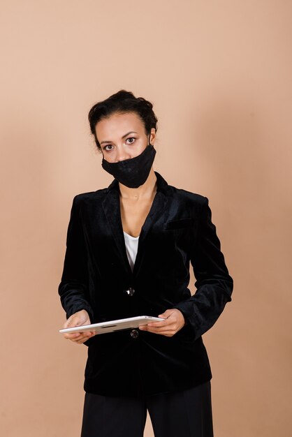 Portret van zwarte onderneemster die gezichtsmasker draagt tijdens virusepidemie in een studio.